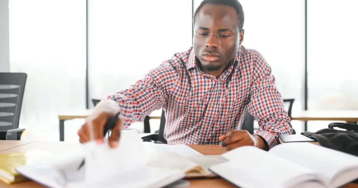 Payroll officer working through paperwork at a desk
